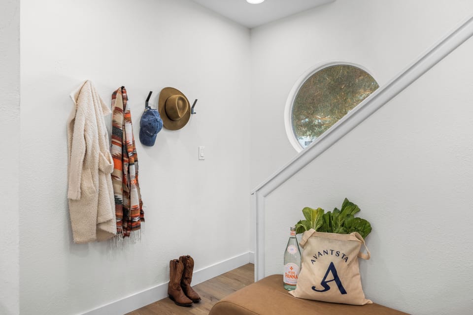 Entryway with coat hooks and a round window.