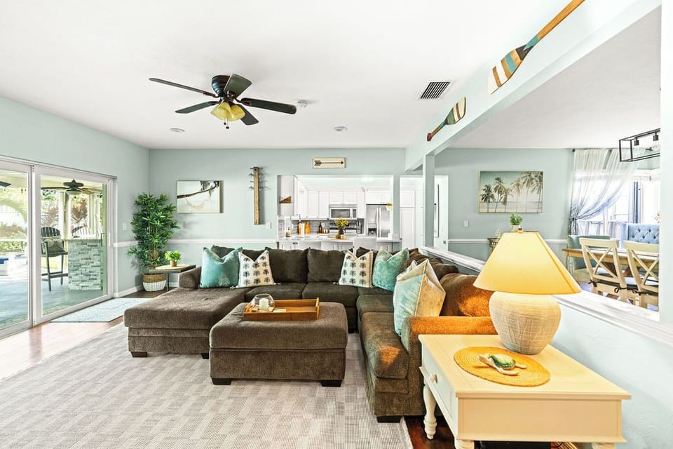 Relax in absolute comfort. 🛋️ This spacious, open living room features a huge sectional and smart TV, offering plenty of seating for the whole family to unwind together.