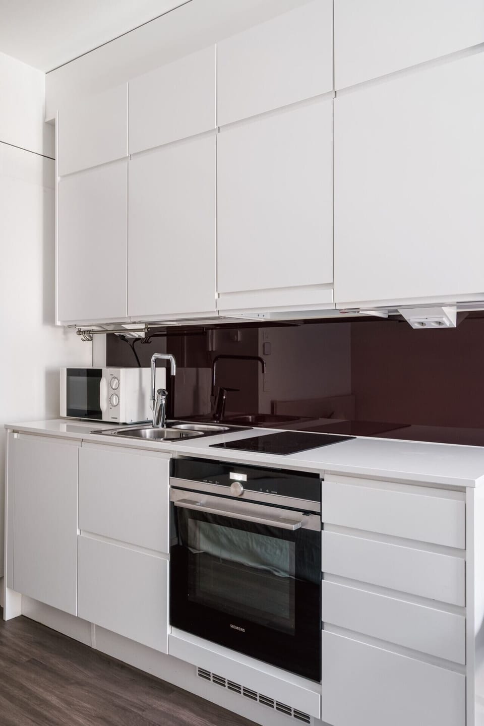 Bright, compact kitchen with all essentials — fridge, stove, kettle, and more.