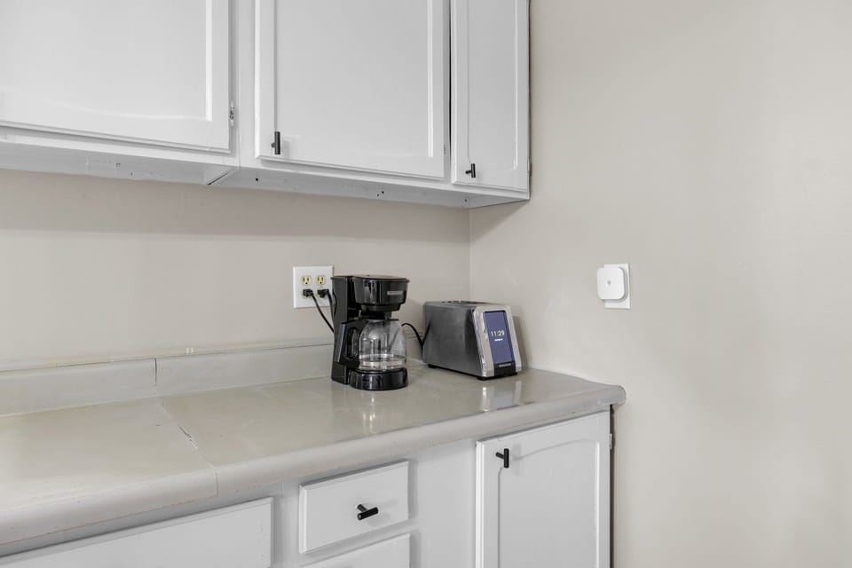 Start your mornings right with your personal coffee station featuring a drip coffee maker and toaster, perfectly positioned for easy access.