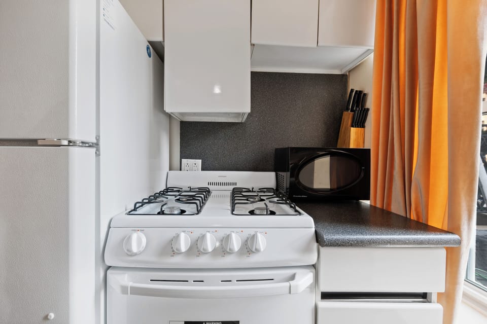 Your compact kitchen features everything you need: gas stove, microwave, and knife set for preparing delicious meals during your stay.