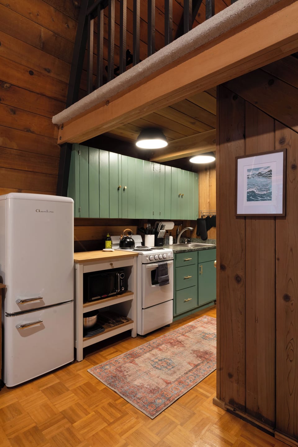 The kitchen has a fridge, stove/oven and microwave