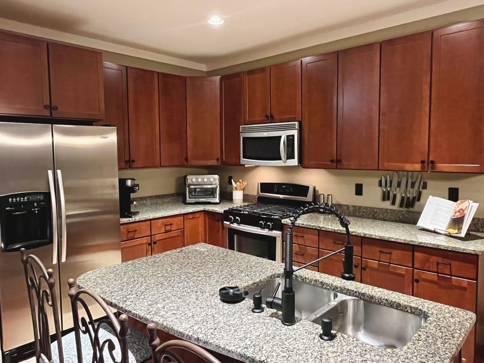 Fully stocked kitchen with a gas range, ice maker, and hands-free faucet.