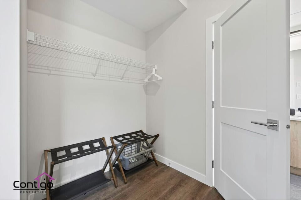 Generous walk-in closet with built-in shelving, dedicated luggage racks, and laundry basket — thoughtfully designed storage for extended stays and ski-season getaways near Kicking Horse Mountain Resort, Golden, BC.