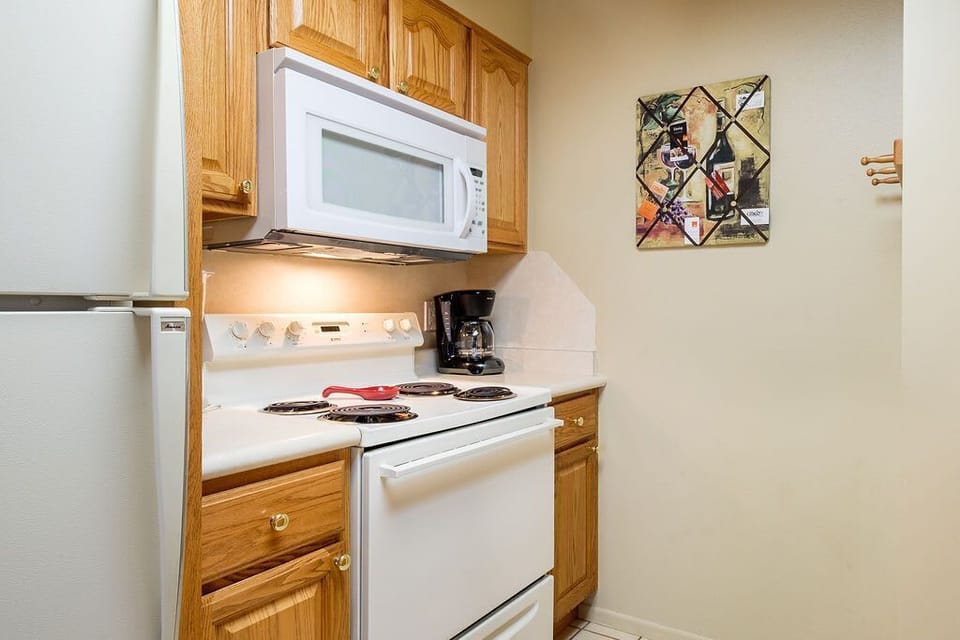 Kitchen side view including microwave, gas stove, and coffee maker