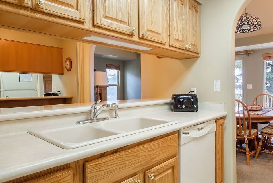 Kitchen side view including dishwasher, toaster, and storage cabinets