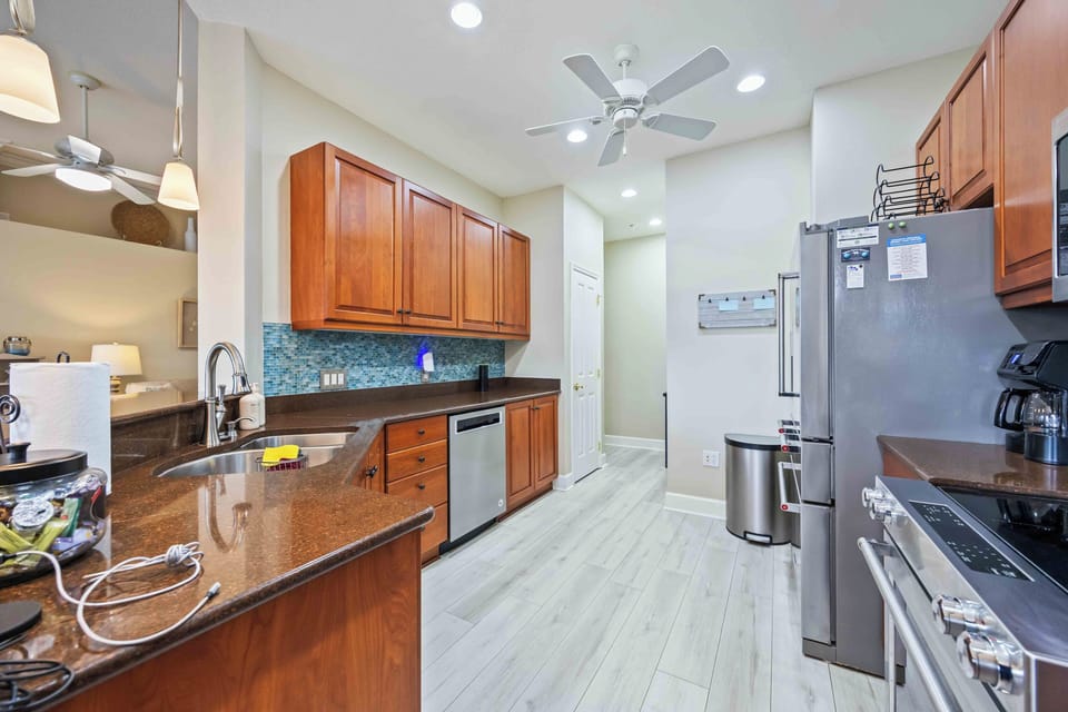 Beautiful kitchen with natural stone countertops, wood cabinets, stainless steel appliances. Includes a coffee maker and double sink.