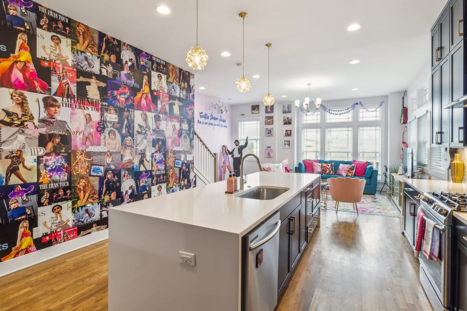 2nd Floor: Fully equipped kitchen with stainless steel appliances, a kitchen island with seating for 4 guests, and mural with Iconic pictures of Taylor Swift.