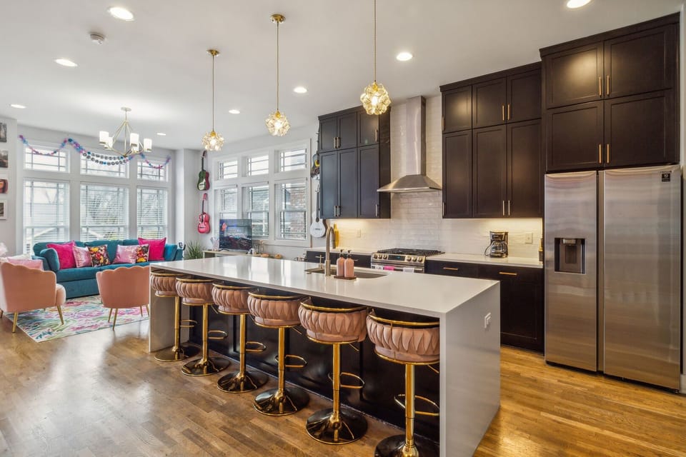 2nd Floor: Fully equipped kitchen with stainless steel appliances, a kitchen island with seating for 4 guests, and mural with Iconic pictures of Taylor Swift.
