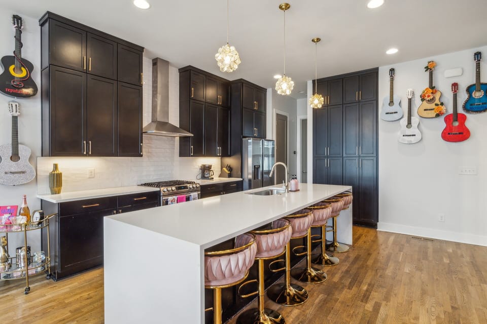 2nd Floor: Fully equipped kitchen with stainless steel appliances, a kitchen island with seating for 4 guests, and mural with Iconic pictures of Taylor Swift.