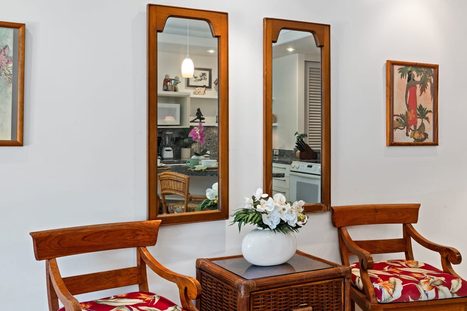 A stylish corner featuring twin mirrors, chic chairs, and a decorative centerpiece