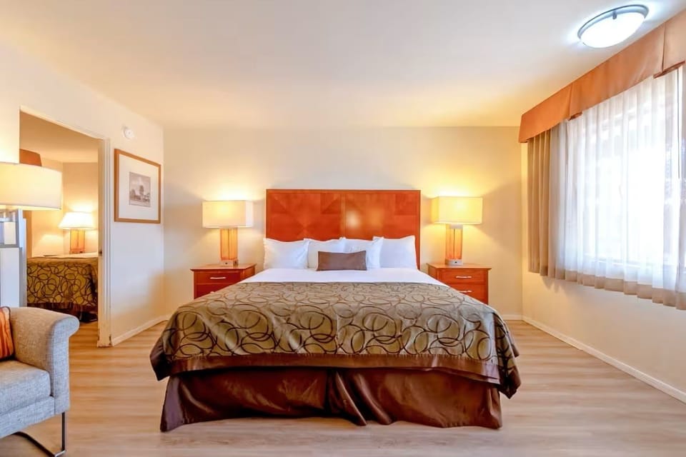 Unwind in a crisp king bed with warm, calming light.