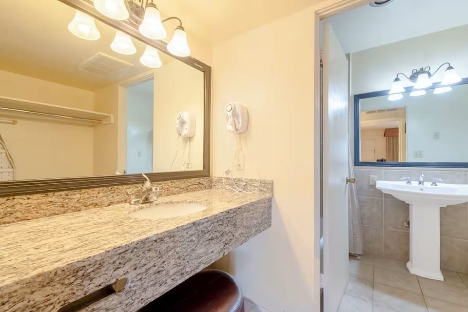 Get ready easily with a wide granite vanity and bright mirror lighting.