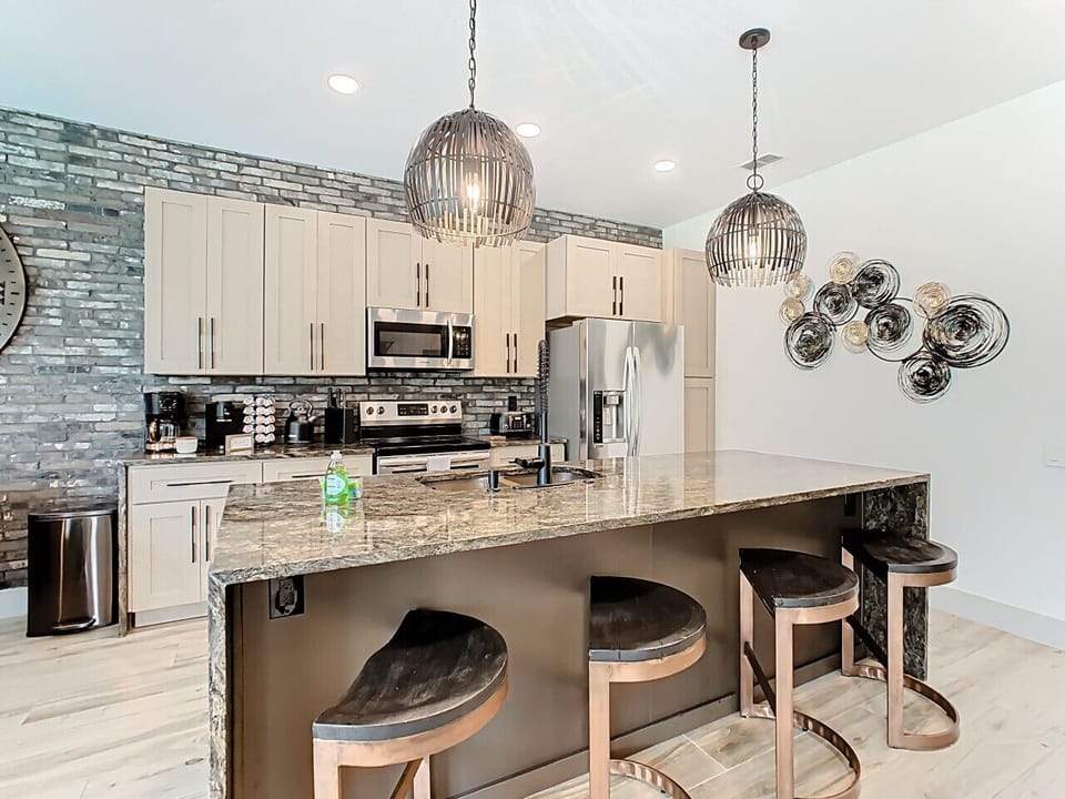 Fully equipped modern kitchen with premium appliances, stylish backsplash, and a generous island perfect for meal prep or casual dining.