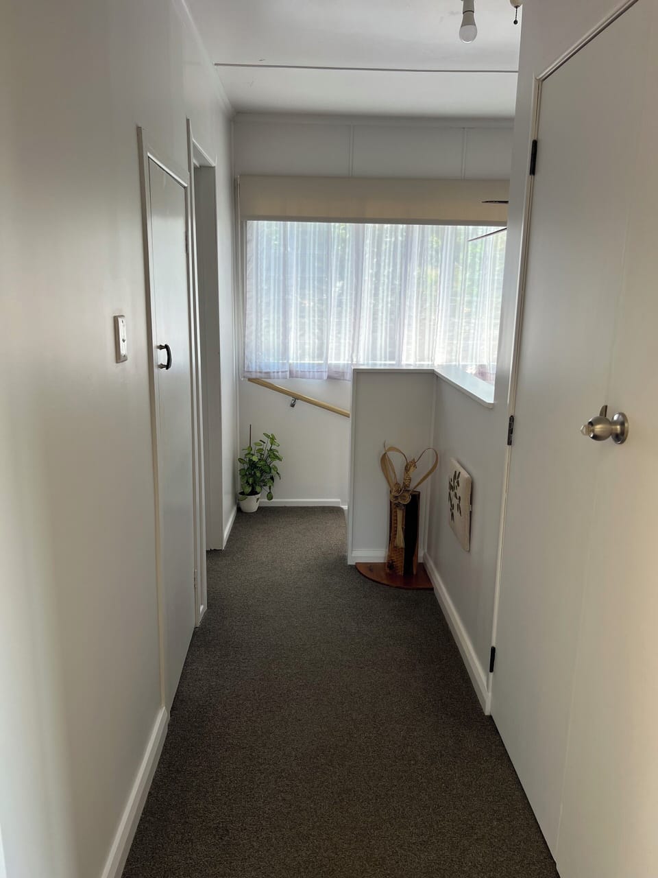 Hallway leading to Bathroom on the left and stairs to bottom bedrooms on right.