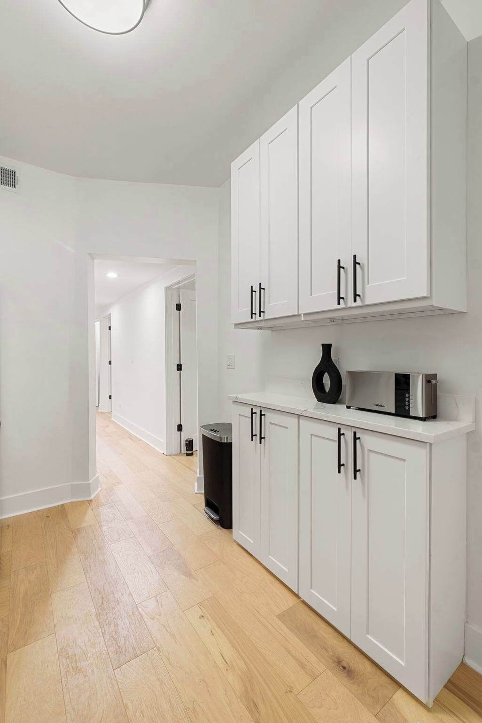 Hallway & entry area w/ light wood floors & a minimalist look.