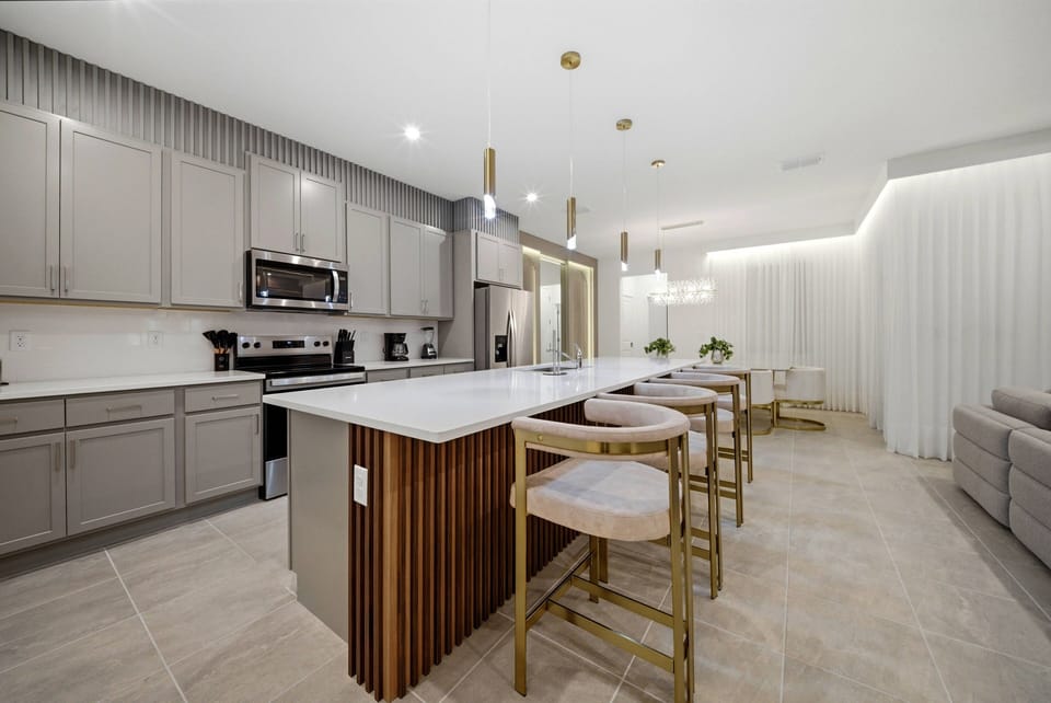 Enjoy our stylish kitchen with sleek gray cabinetry and warm wood accents, creating a cozy yet contemporary atmosphere. The spacious island is perfect for casual dining, illuminated by chic pendant lights that elevate the design.