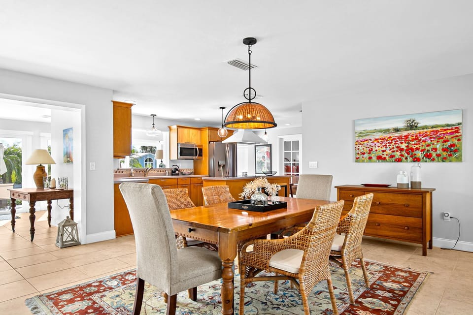 Gather around this inviting dining space where warm wood tones and wicker chairs create the perfect setting for your morning coffee or evening meals with loved ones.