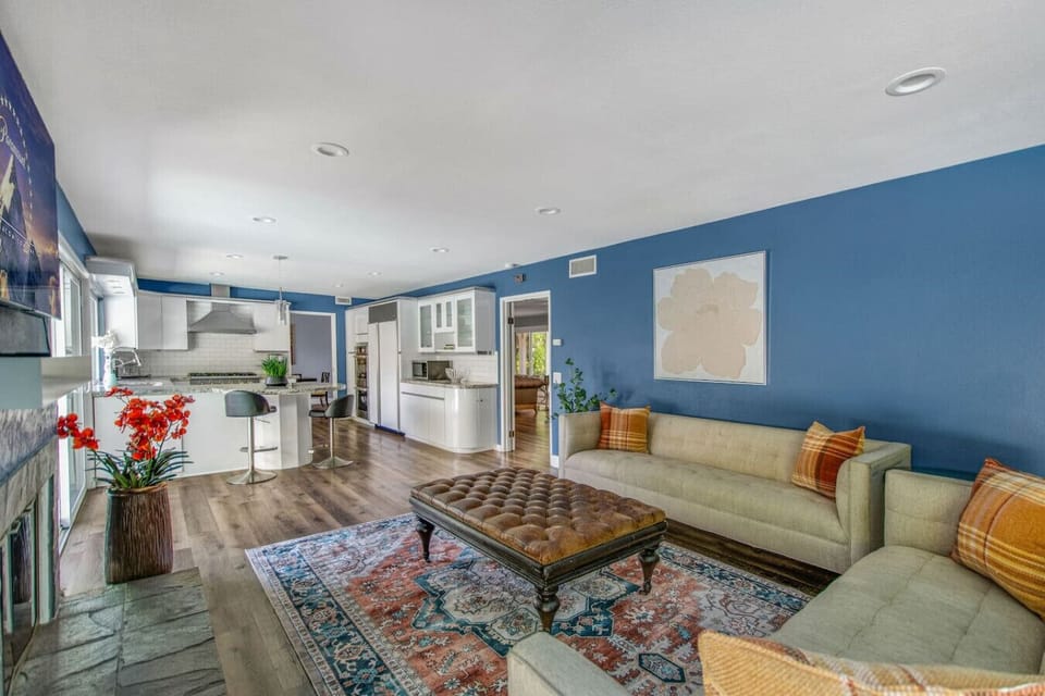 Bright open-concept living room with comfortable seating, stylish décor, and seamless flow into the kitchen and dining area.