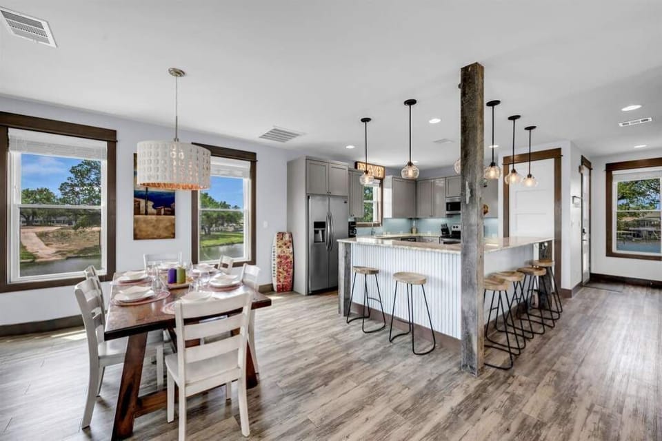 Open kitchen and dining area with extra seating around the bar. 