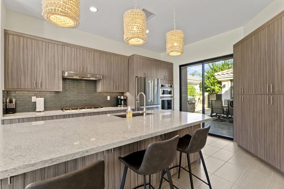 Gourmet kitchen w/ large island, bar seating & sleek cabinetry, perfect for cooking & gathering