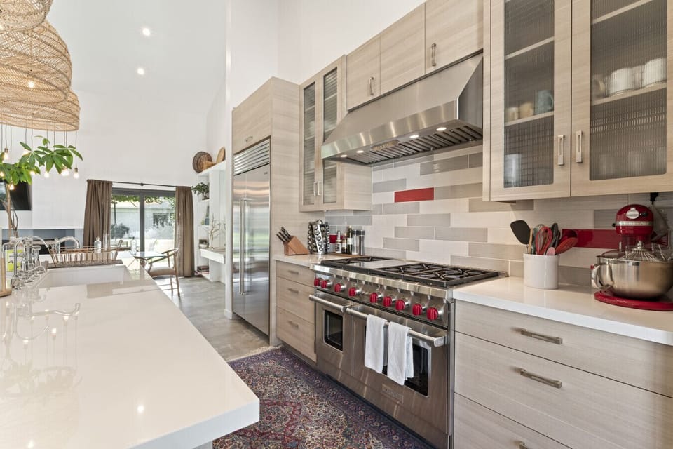 Chef’s kitchen with quartz countertops and Wolf stainless steel appliances.