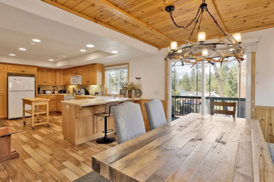 Bright dining nook with seating for six, offering charming garden views