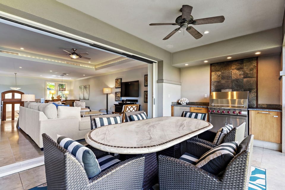 A spacious outdoor dining area featuring a large table, BBQ grill, and comfortable seating, perfect for enjoying meals al fresco