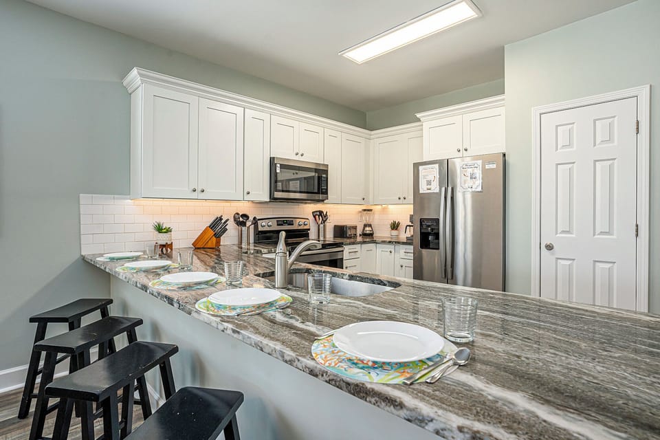 Cook, dine, and relax together in this clean, spacious kitchen with seating for the whole crew.