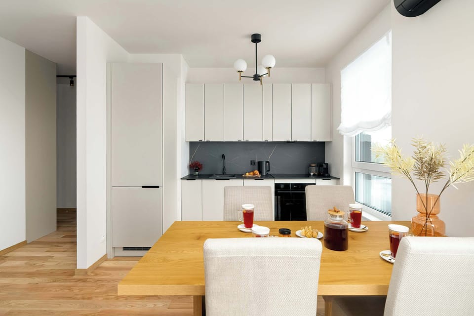 Fully equipped kitchen & dining area with modern finishes and wooden flooring.