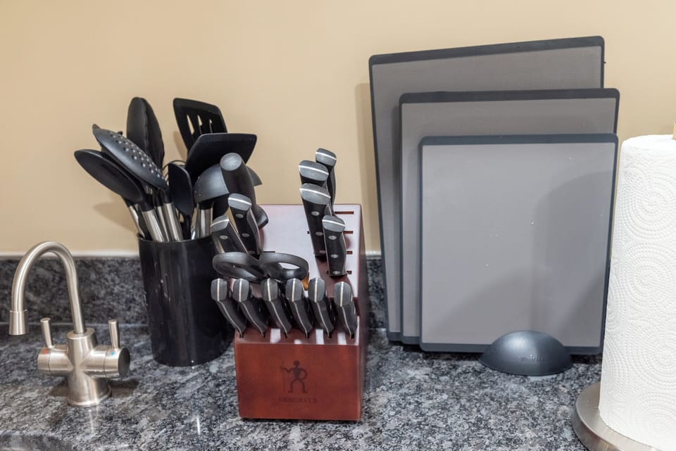 Premium details make cooking a pleasure — Henckels knives, full utensil set, cutting boards, and an instant hot & cold filtered-water tap for convenience and comfort.