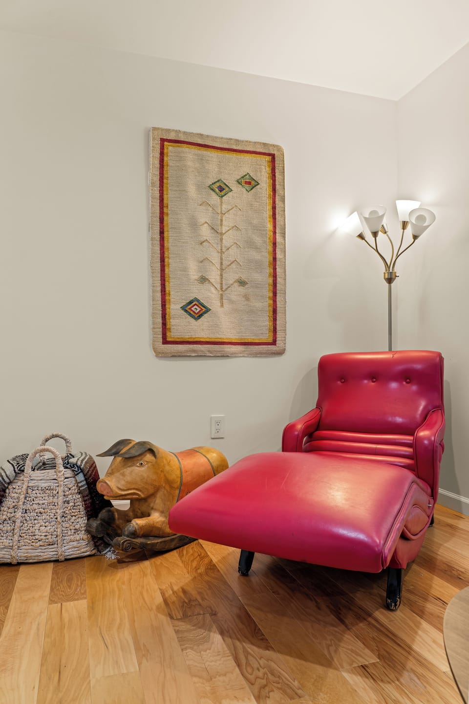 Unwind in your own cozy reading corner, where a vibrant red leather chaise invites you to curl up beneath warm lamplight and thoughtful décor.