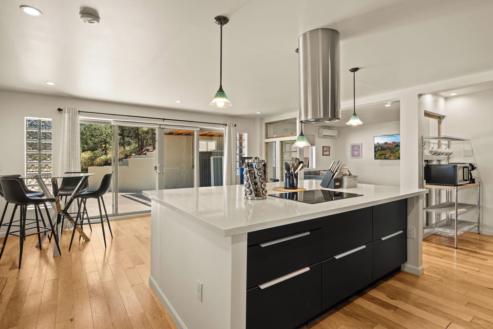 Picture yourself cooking in this sleek, modern kitchen, where a spacious island invites you to prep meals or gather with friends. Natural light pours through the doors, connecting you to your private outdoor space.