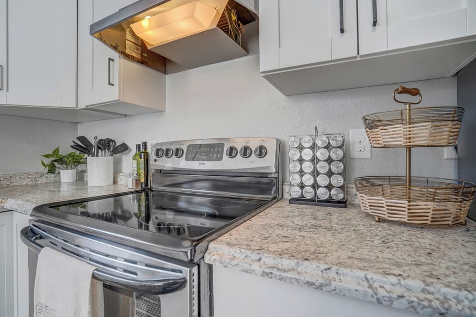Your modern kitchen awaits with gleaming stainless steel appliances and granite countertops. You'll love preparing meals with quality cookware and spice racks at your fingertips in this bright, fully-equipped space.