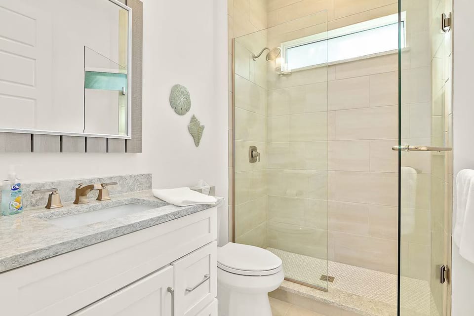 Bathroom featuring a white vanity and a glass-enclosed walk-in shower.