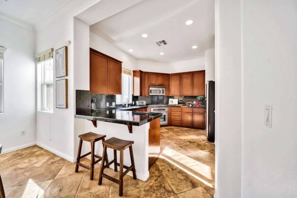 Fully equipped kitchen with plenty of work space and bar stools at the counter
