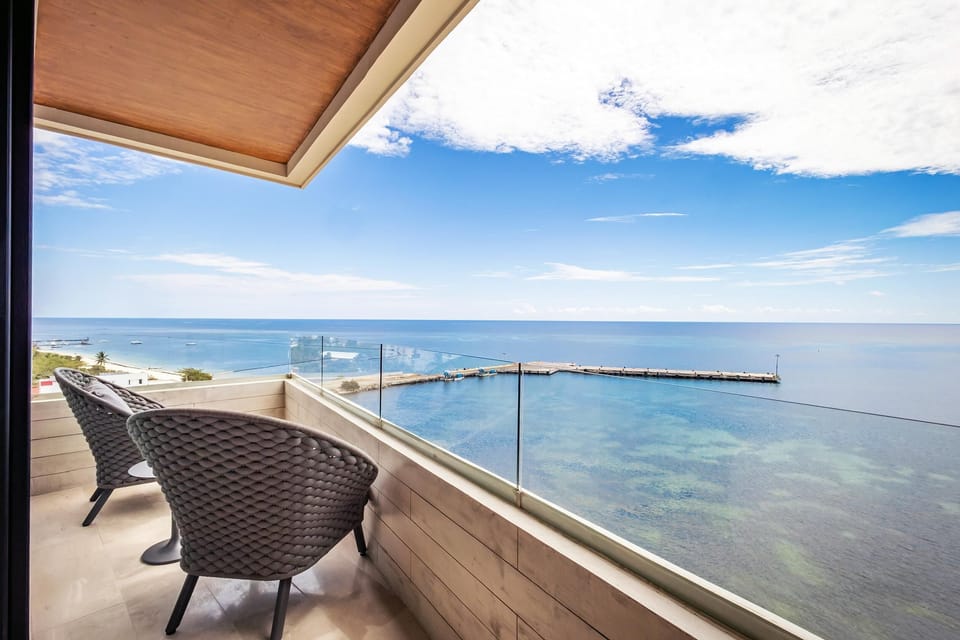 sea front balcony with panoramic water views and cozy seating
