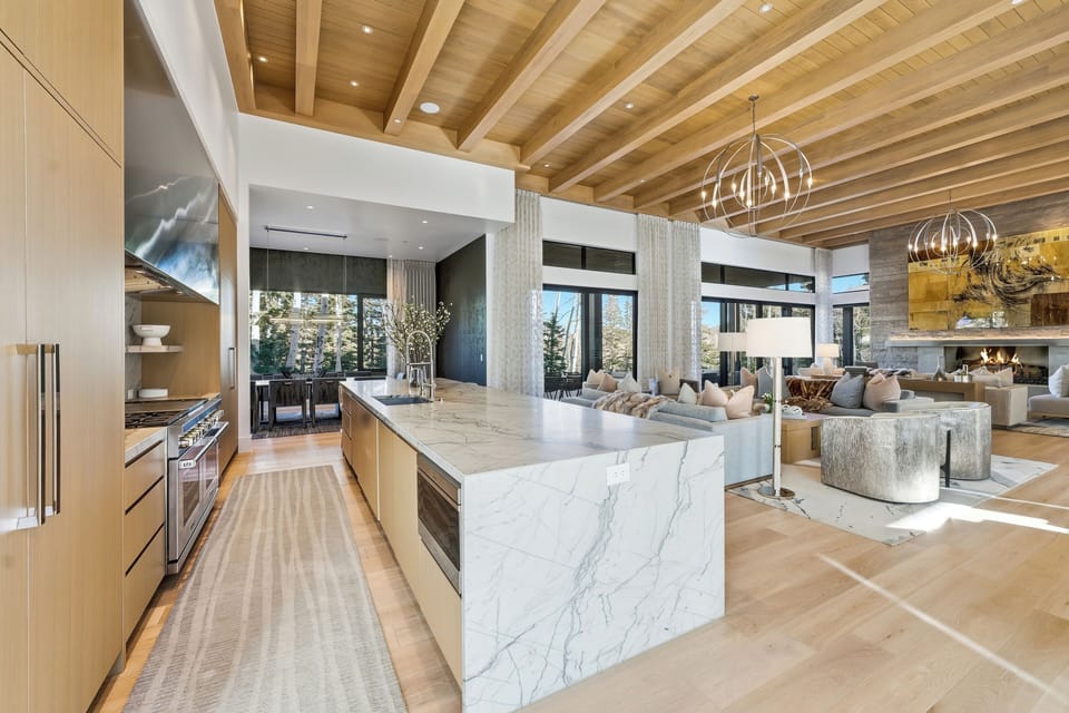 Gourmet kitchen with luxury appliances, waterfall-edge island, and open connection to the dining and living spaces.