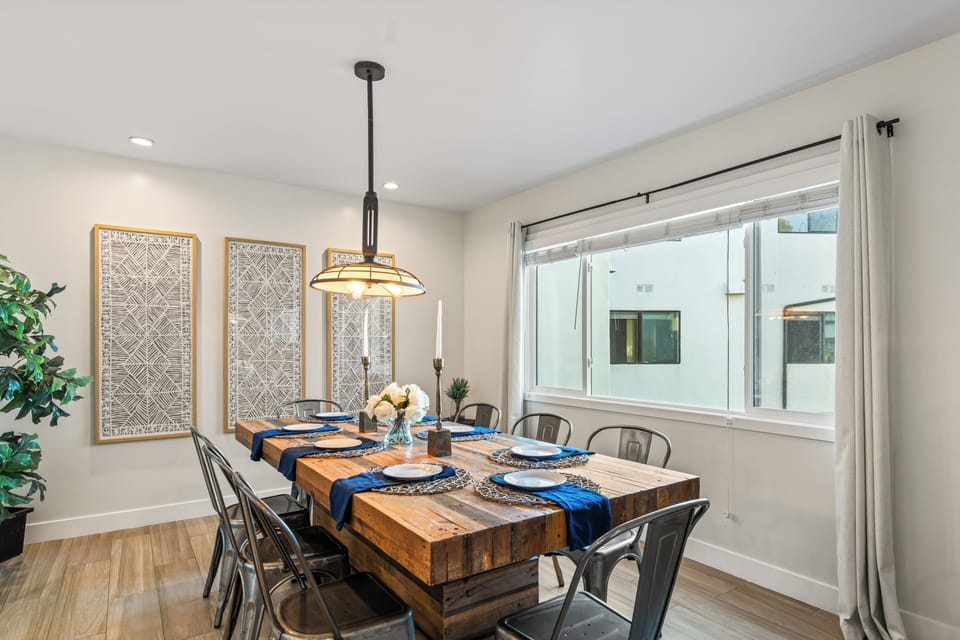 Unit 2: Dining area with large windows and a wooden table.