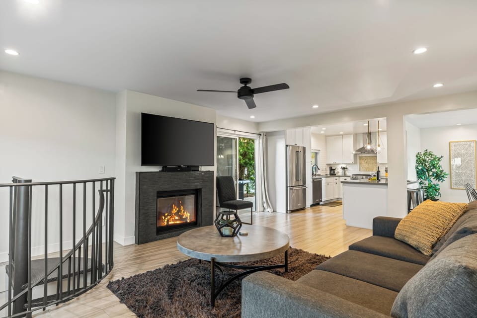 Unit 2: Cozy living room with fireplace, TV, ceiling fan, and sofa.