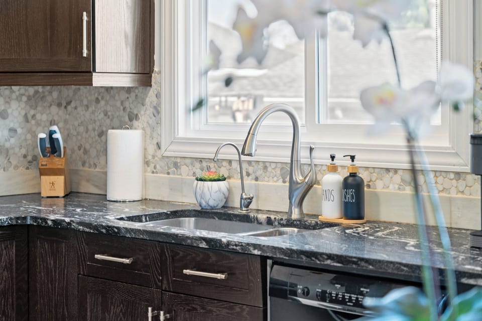 Well-equipped kitchen sink and prep area coffee-ready.