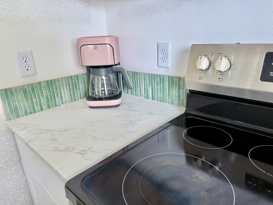 Newly updated with kitchen with white shaker cabinetry, key lime backsplash, and fully stocked for meals at home!
