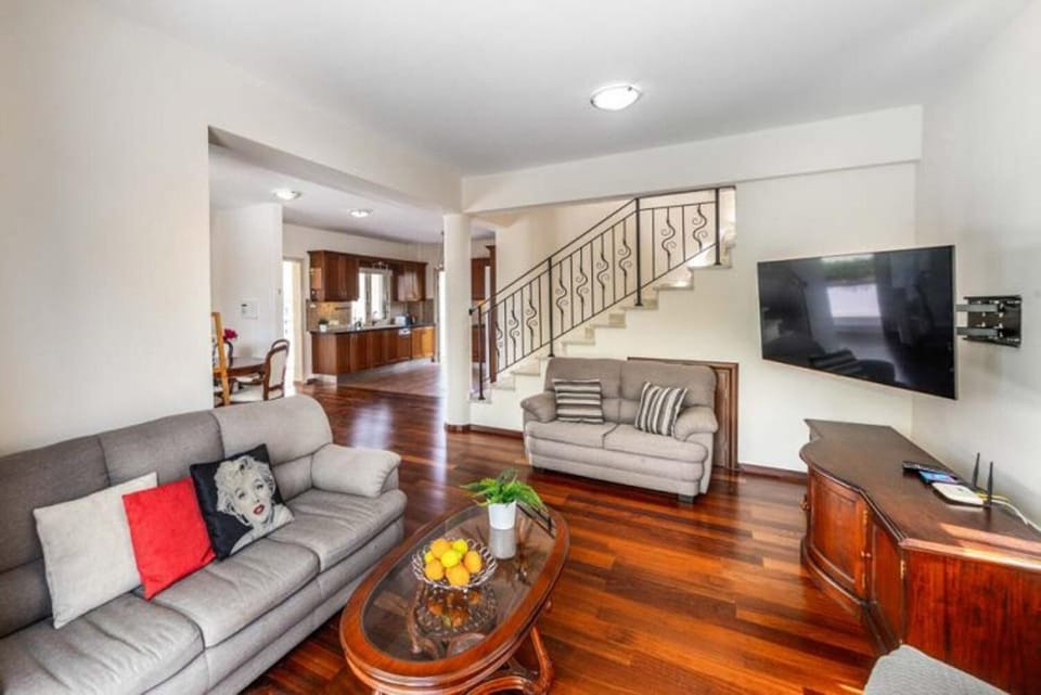 Open-plan living room with sofa, dining area, kitchen, A/C, WiFi internet, and satellite TV