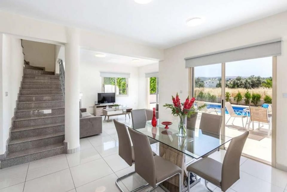 Open-plan living room with sofa, dining area, kitchen, A/C, WiFi internet, and satellite TV