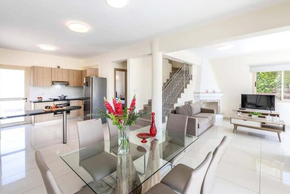 Open-plan living room with sofa, dining area, kitchen, A/C, WiFi internet, and satellite TV