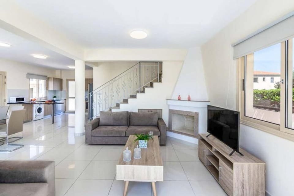 Open-plan living room with sofa, dining area, kitchen, A/C, WiFi internet, and satellite TV