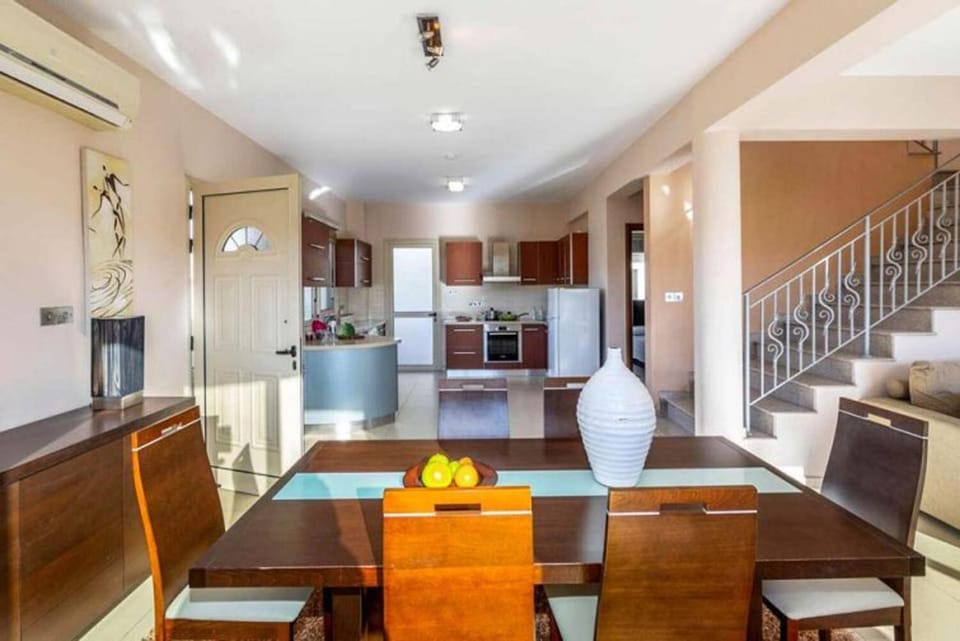 Open-plan living room with sofa, dining area, kitchen, A/C, WiFi internet, and satellite TV