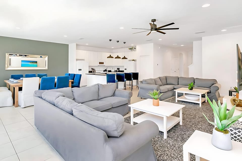 Spacious Open Living Area With Plush Sectional Sofa And 65" Smart TV