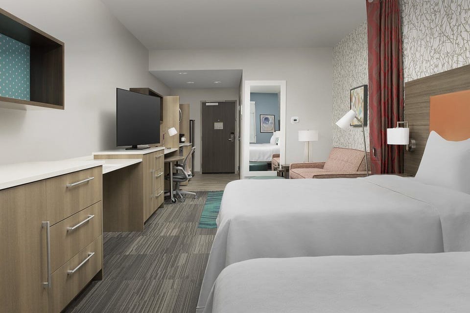 Step into a roomy retreat with desk, TV, and comfort.