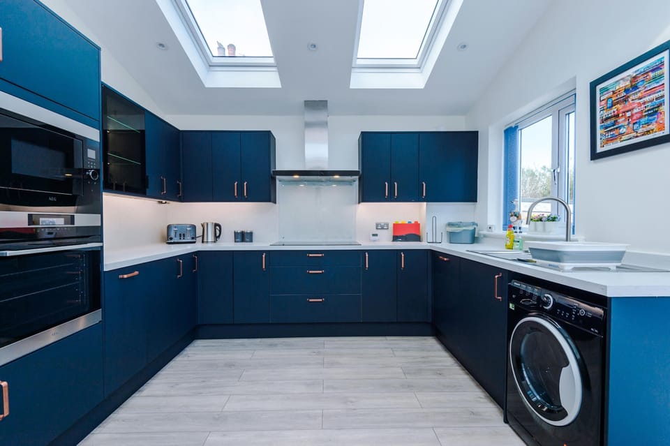 Well-equipped utility kitchen with a washing machine and dishwasher, making longer stays hassle-free
